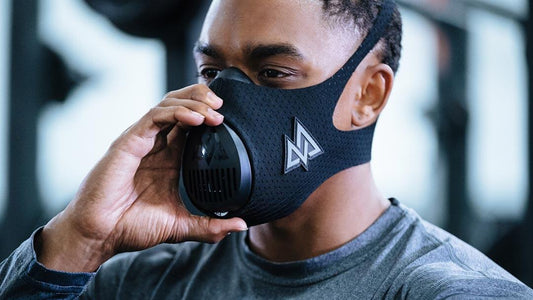 a man adjusting his training mask at the gym