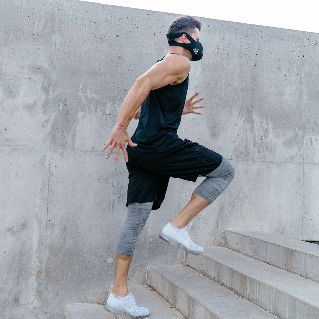 TrainingMask being used by man running up concrete stairs