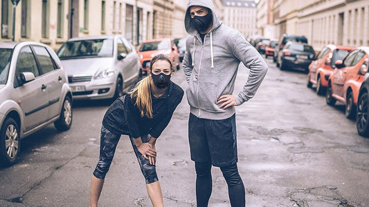 a guy and a girl posing on a parking space with trainingmask on their faces