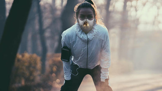 a girl resting after running in the woods while wearing a training mask