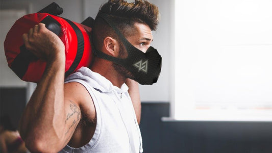 a guy with a weighted bag on his shoulder with a trainingmask