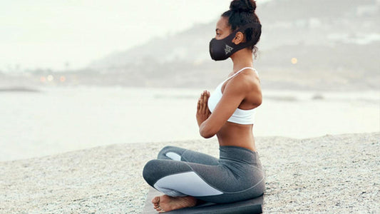 lady on the beach wearing trainingmask 3.0 doing yoga meditation