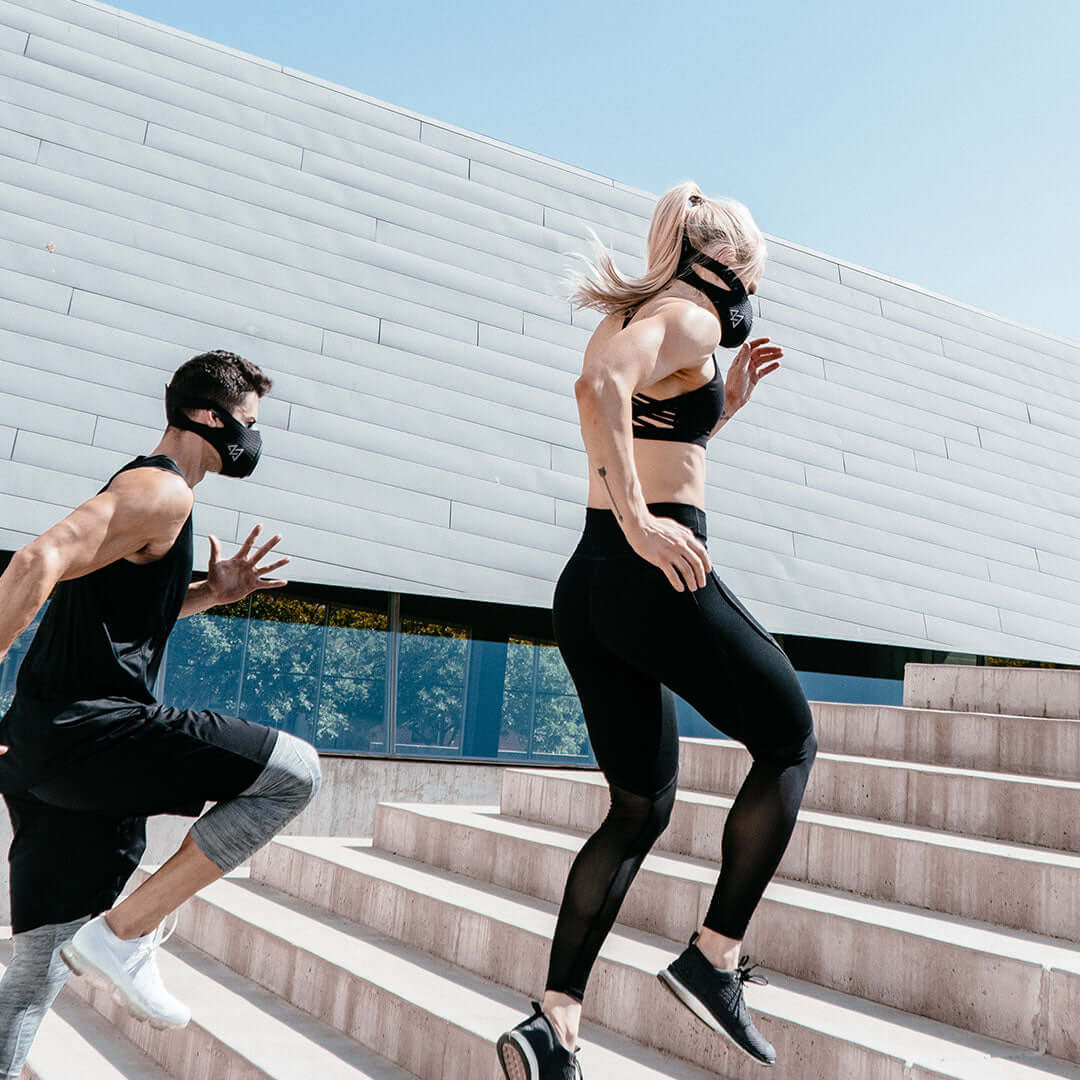 Man and women running up stairs with masks on